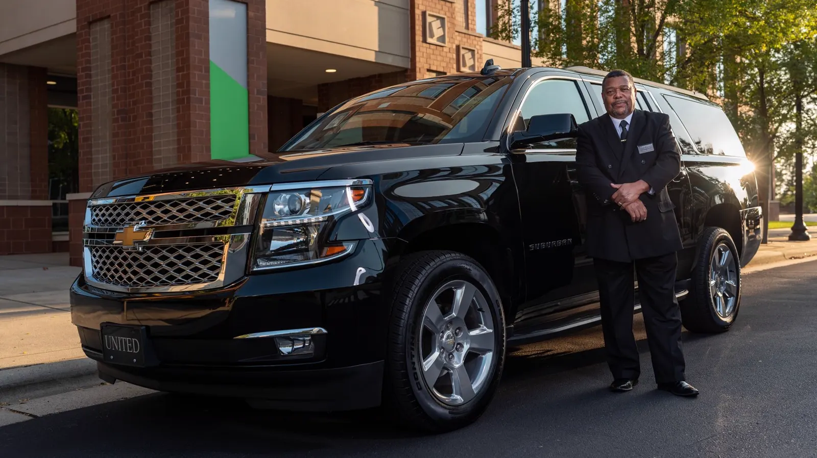 Rock N Rides 406 driver standing beside a black SUV ready for an airport pickup